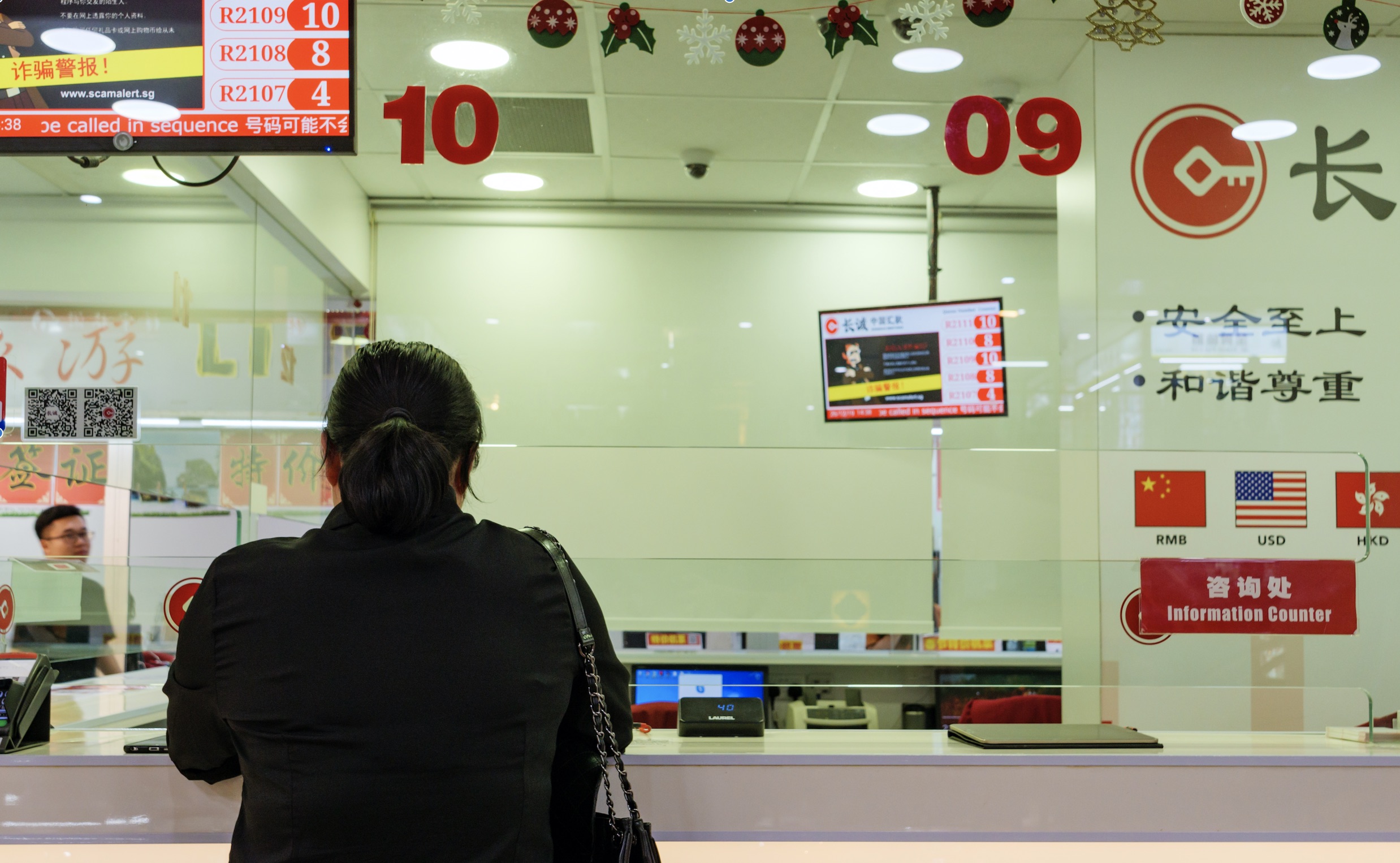 Woman at kiosk doing international banking transaction